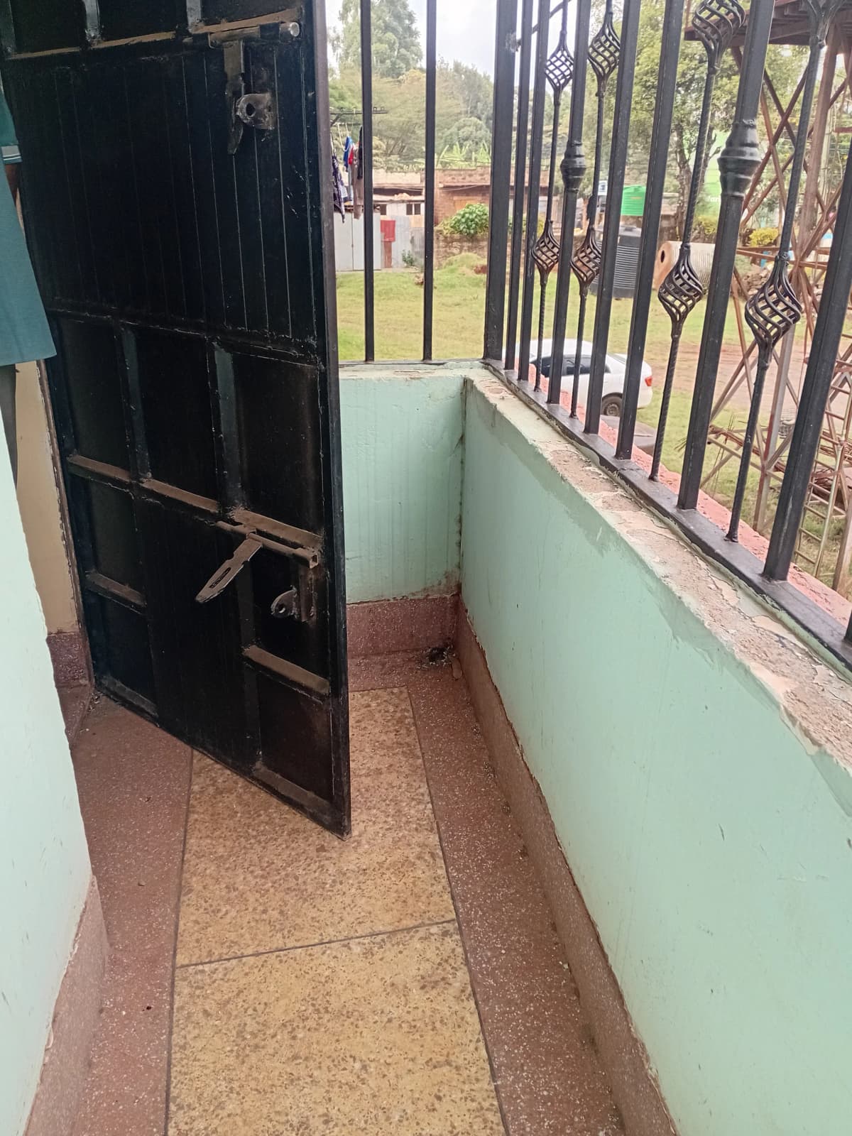 Narrow balcony with metal gate and compound view