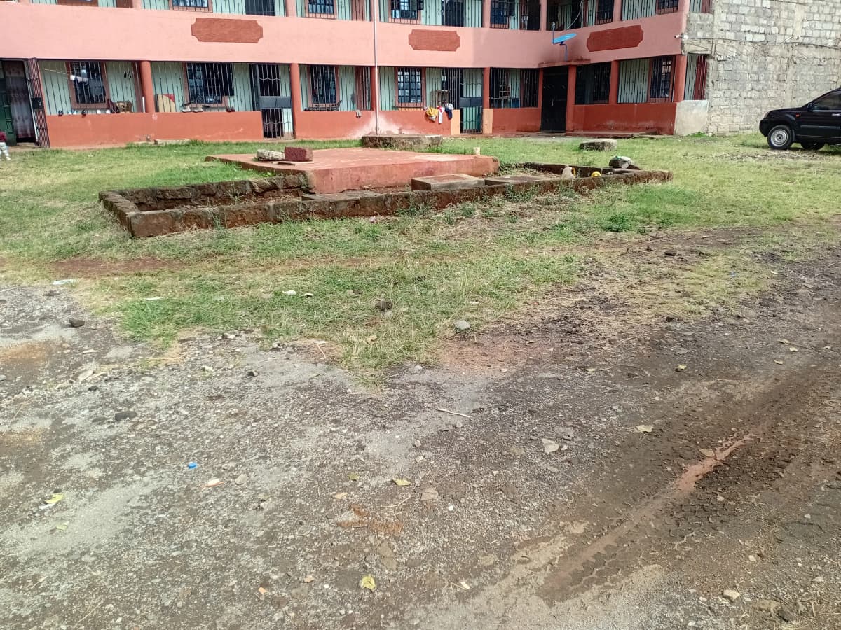 Compound grounds with red-brick building and landscaping.