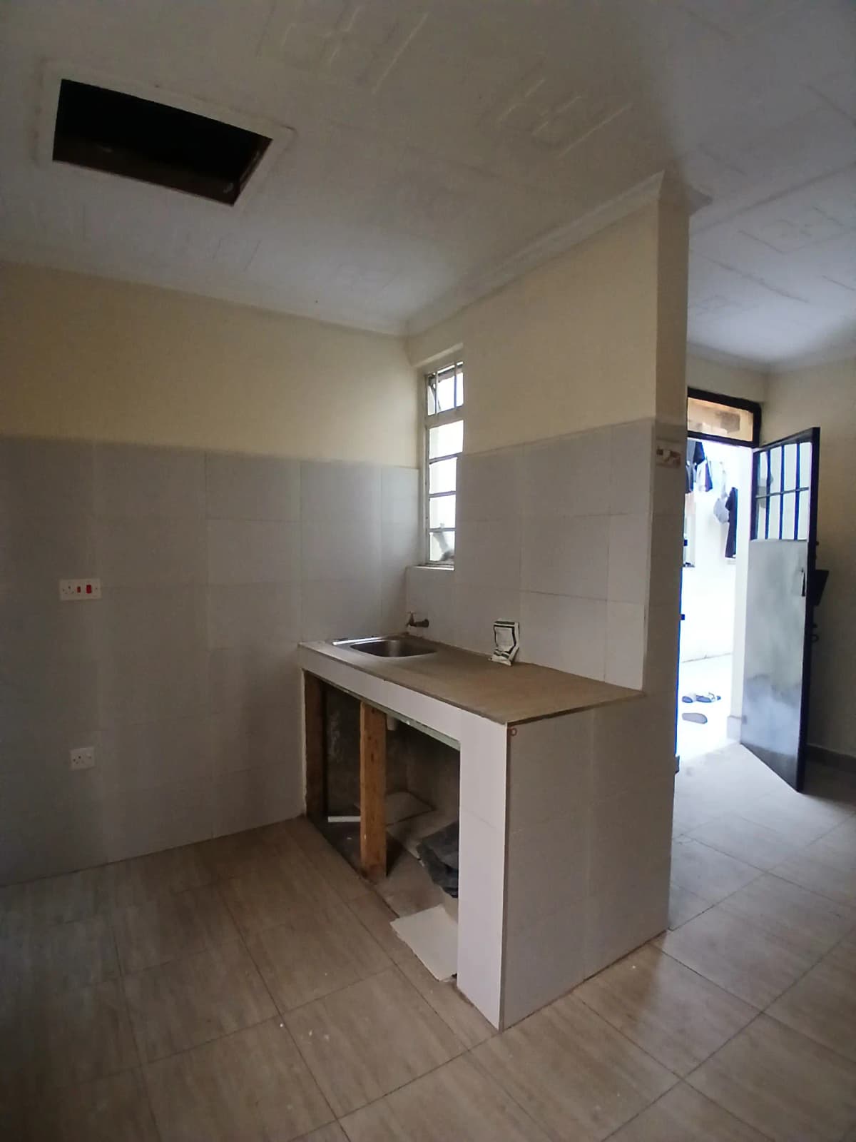 Compact kitchen with basic sink and counter space, natural light