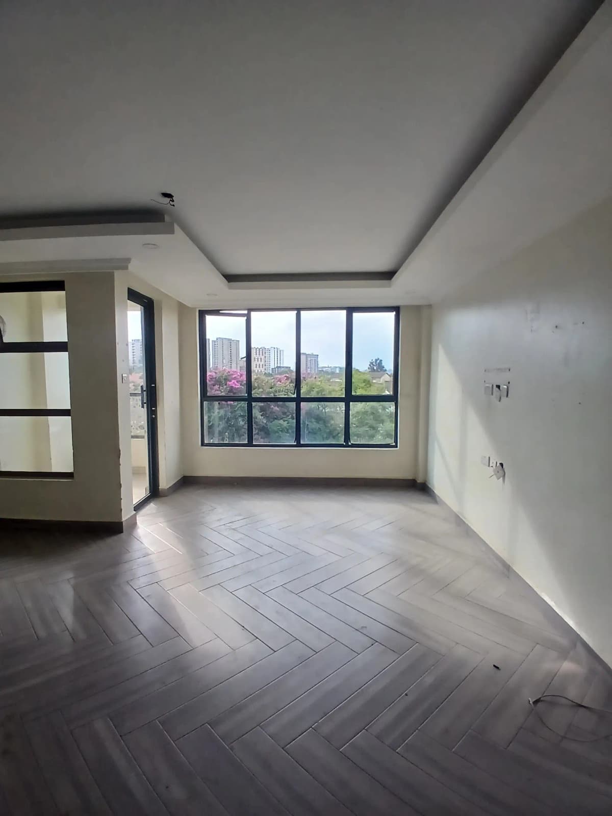 Spacious living room with herringbone flooring and panoramic windows