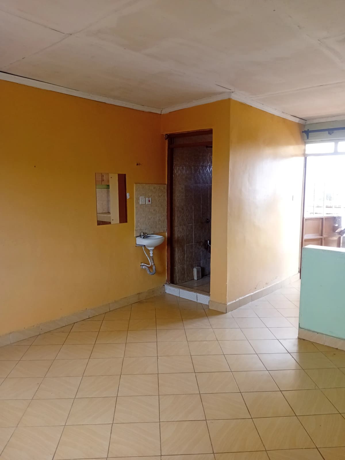 Bright yellow corridor with tile flooring and utility fixture