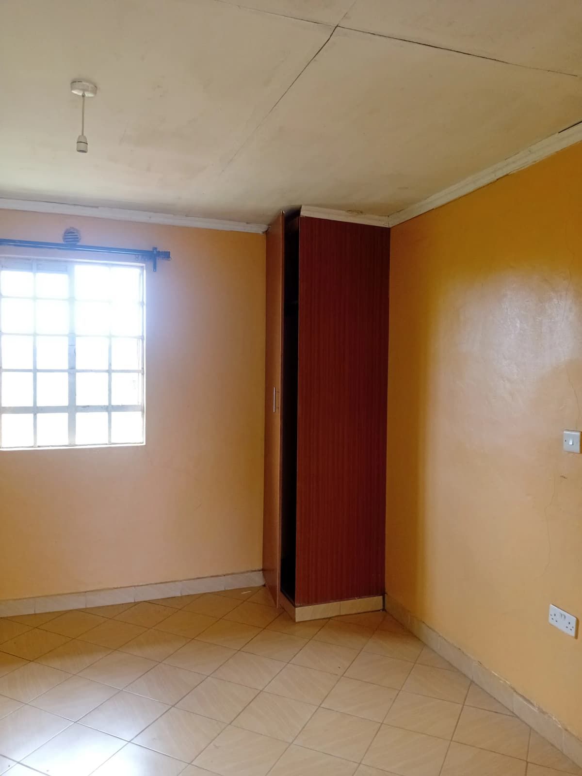 Empty bedroom with yellow walls and natural light