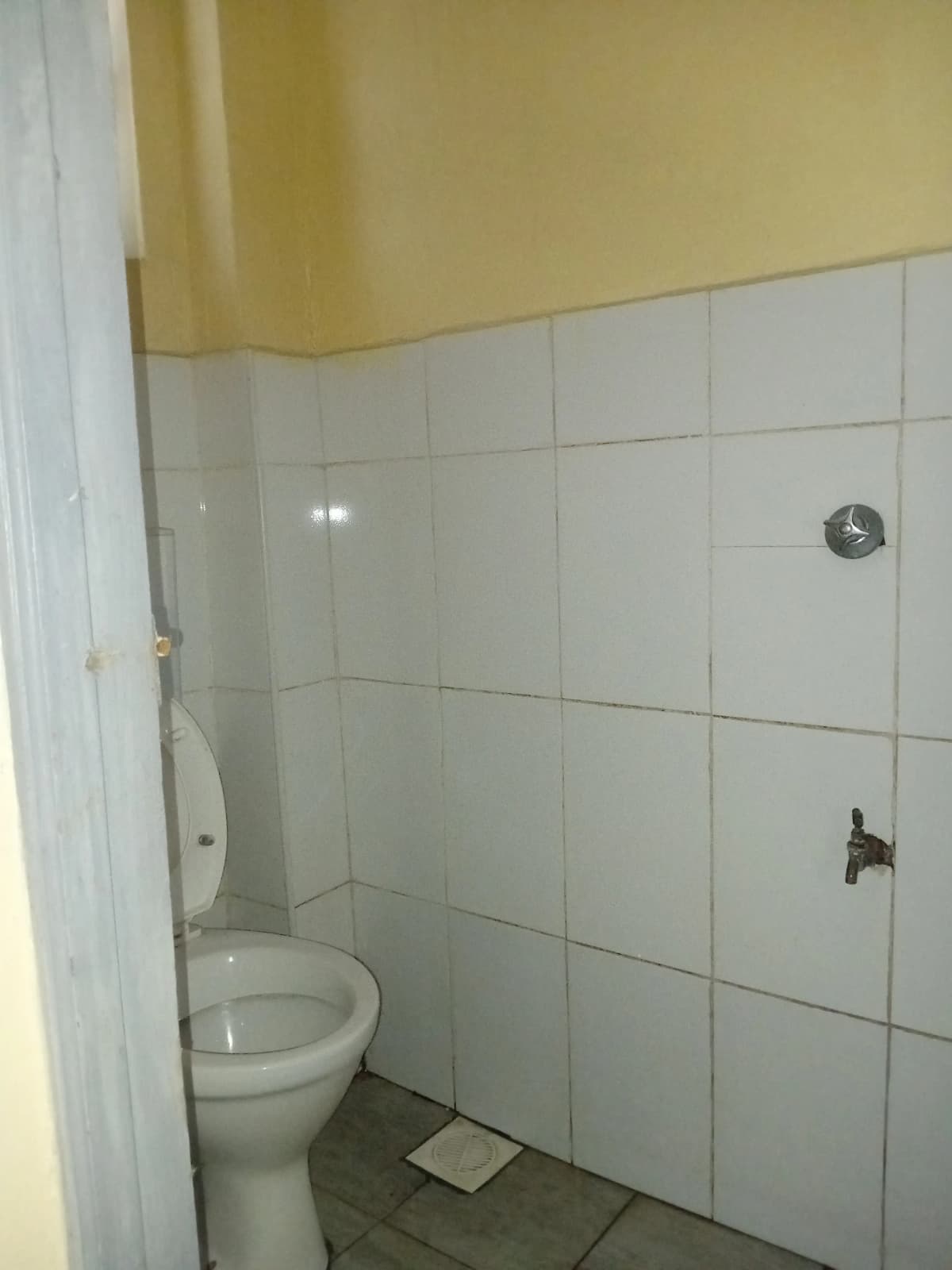 Bathroom with toilet, shower enclosure, white tiling