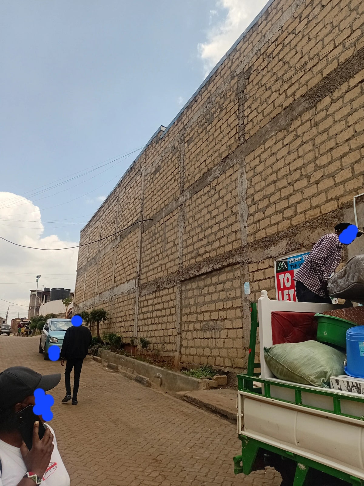 Brick building facade with street frontage and parked vehicle