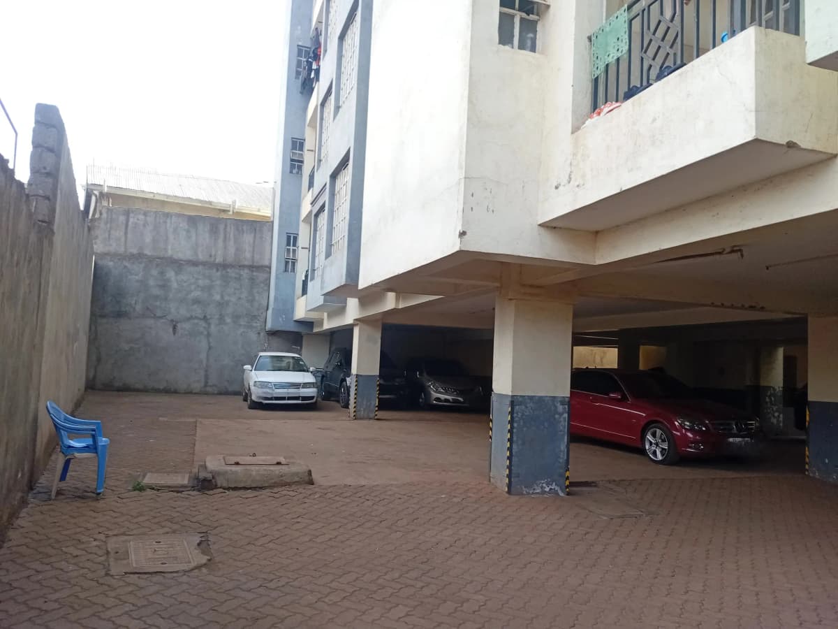 Covered parking area with multiple vehicles under building