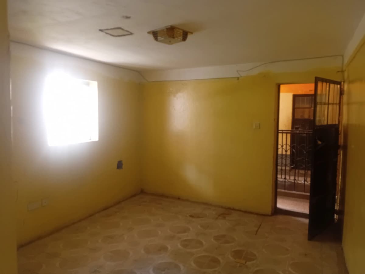 Spacious bedroom with yellow walls and natural light