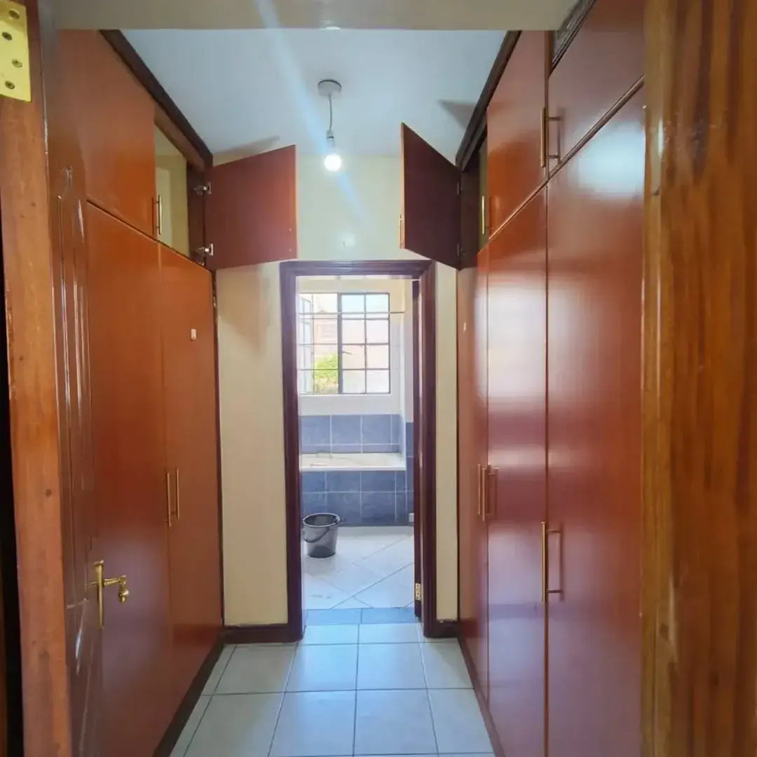 Narrow hallway with wooden doors and tiled flooring