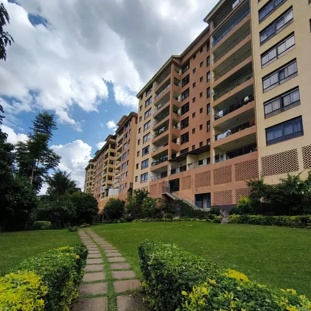 Multi-story residential building with manicured compound grounds