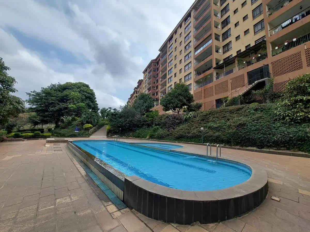 Olympic-length swimming pool with lush compound grounds