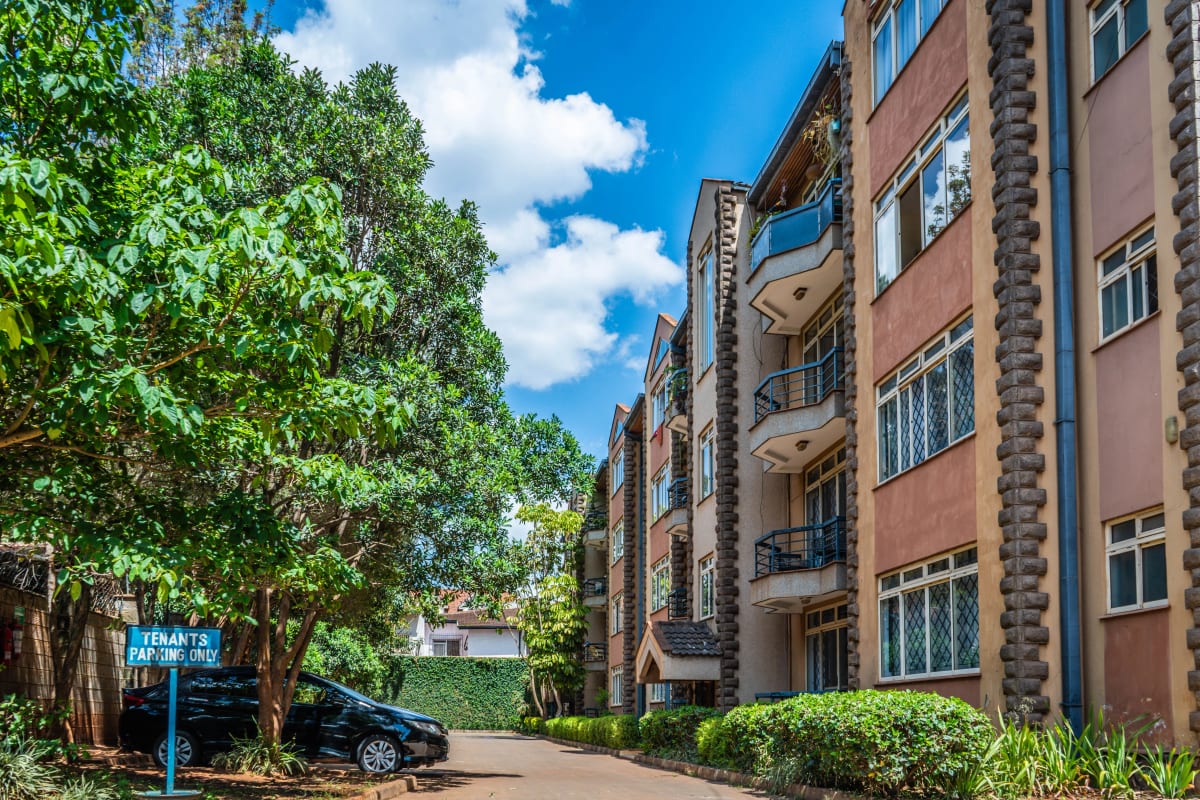 Multi-story residential building with manicured compound and driveway