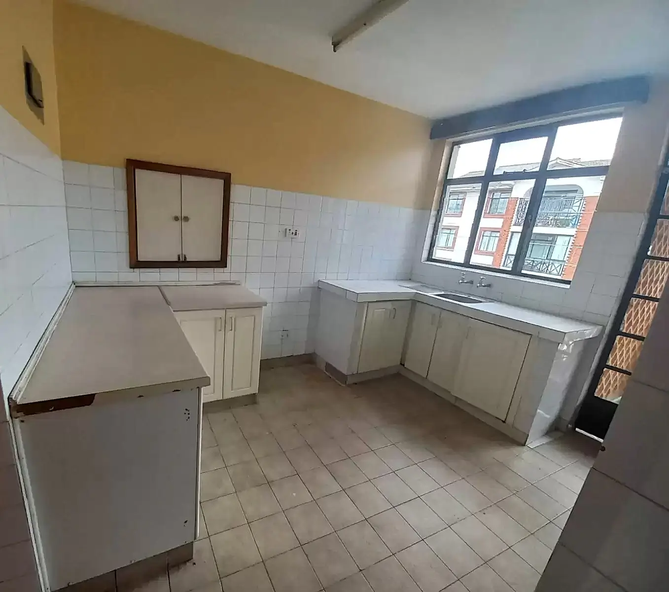Spacious kitchen with counter units and natural light