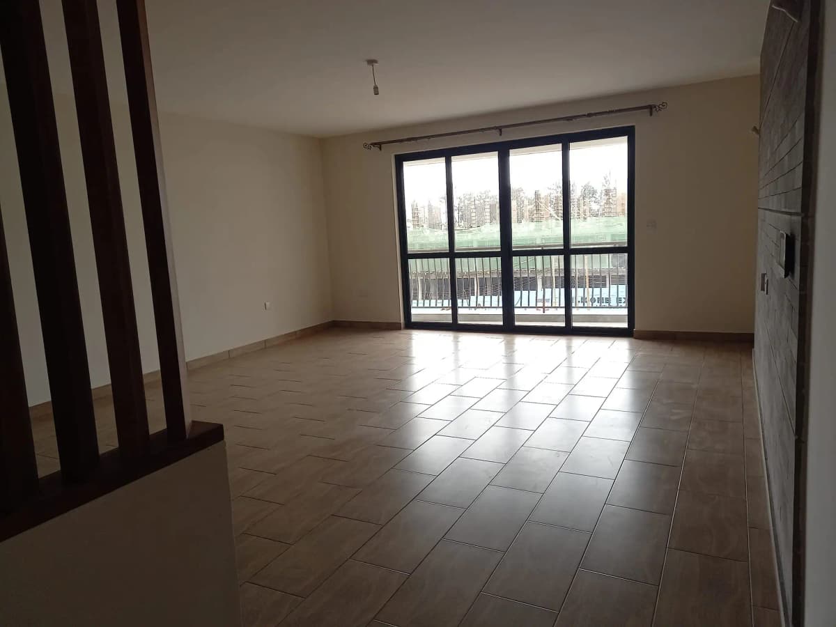 Spacious living room with tile flooring and balcony access