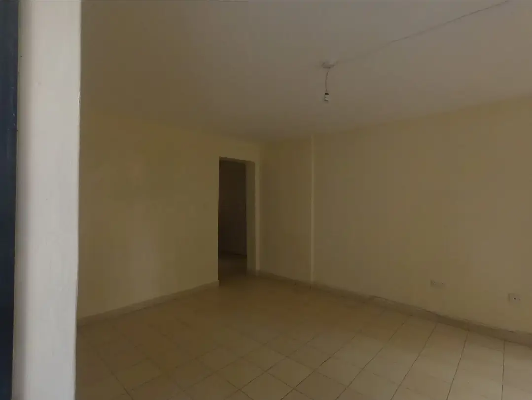 Empty living room with beige walls and tiled flooring