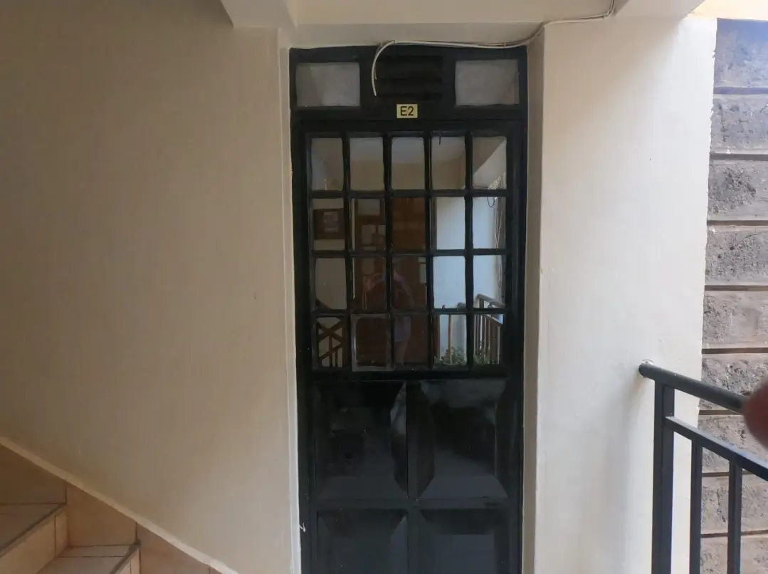 Black-framed glass door entrance in modern lobby corridor