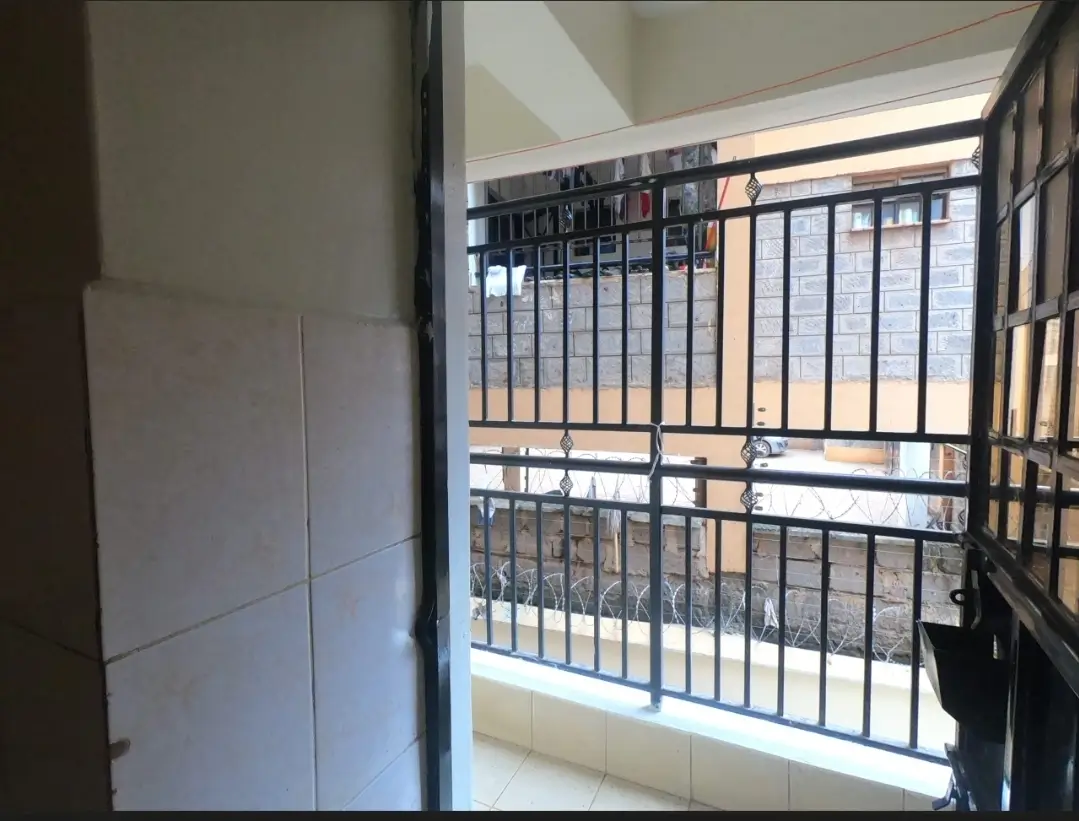 Balcony with metal railings overlooking residential compound