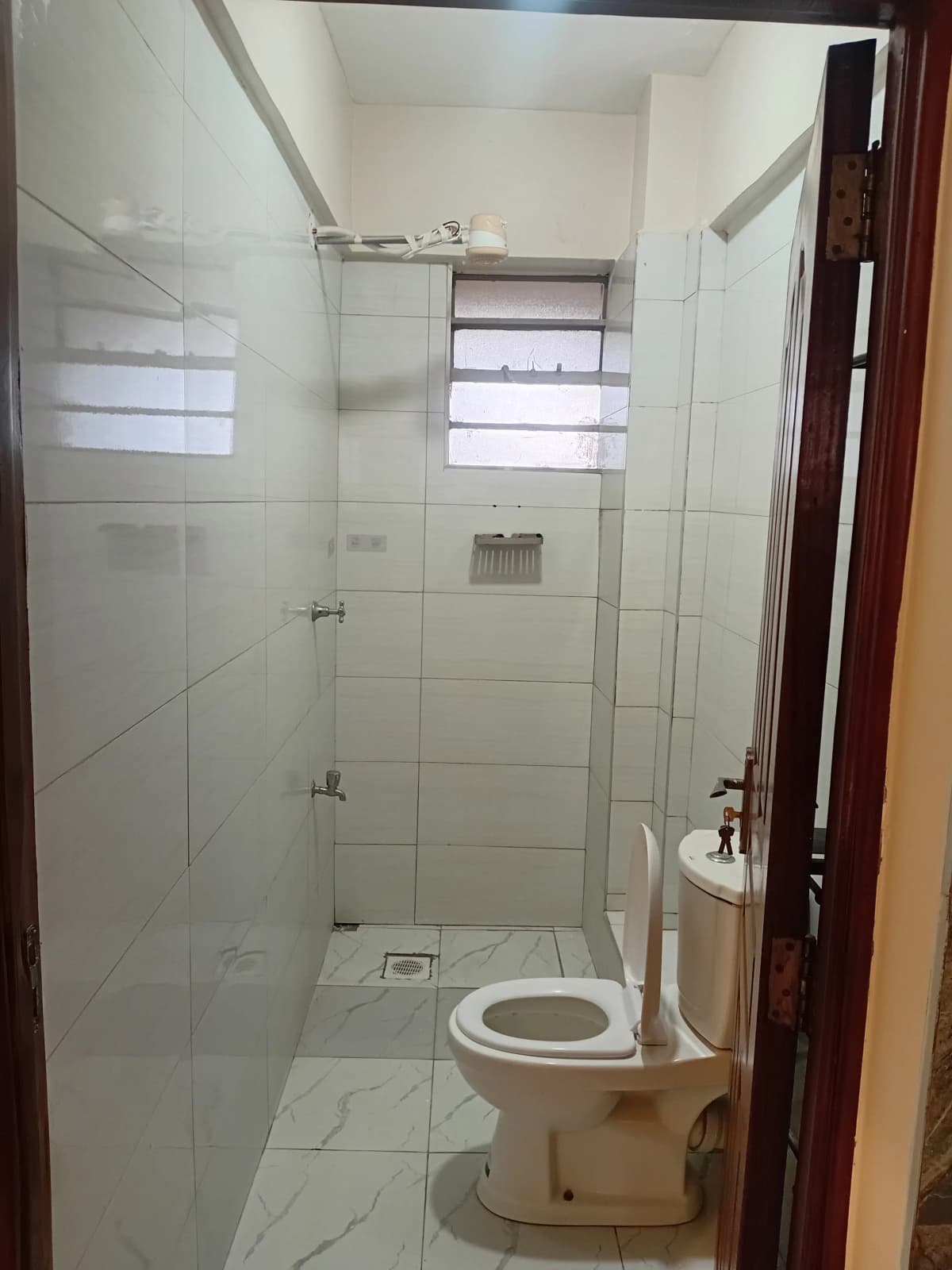 Compact bathroom with walk-in shower and toilet fixture