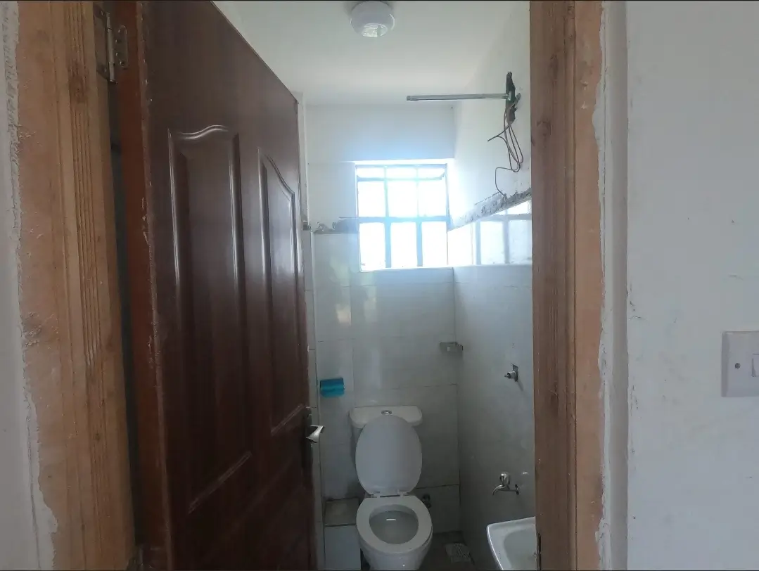 Compact bathroom with toilet and small window