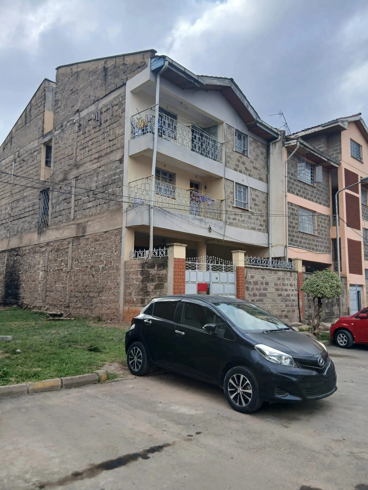Multi-story residential building facade with parked vehicles