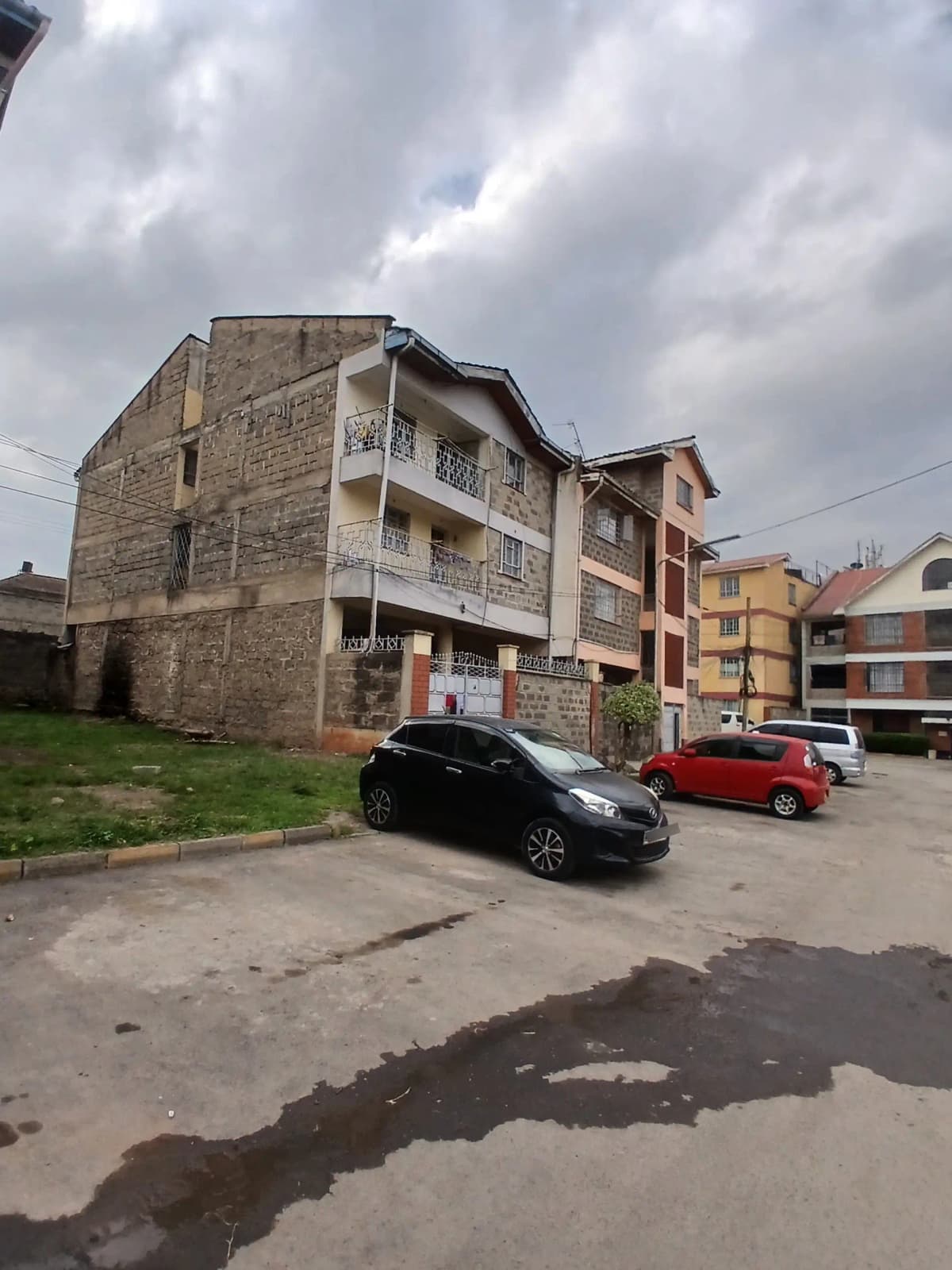 Multi-story residential building with parking area and compound grounds