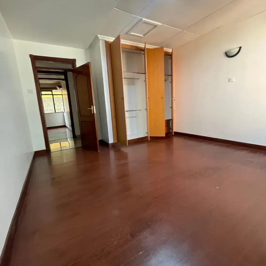 Spacious bedroom with built-in wardrobes and wooden flooring