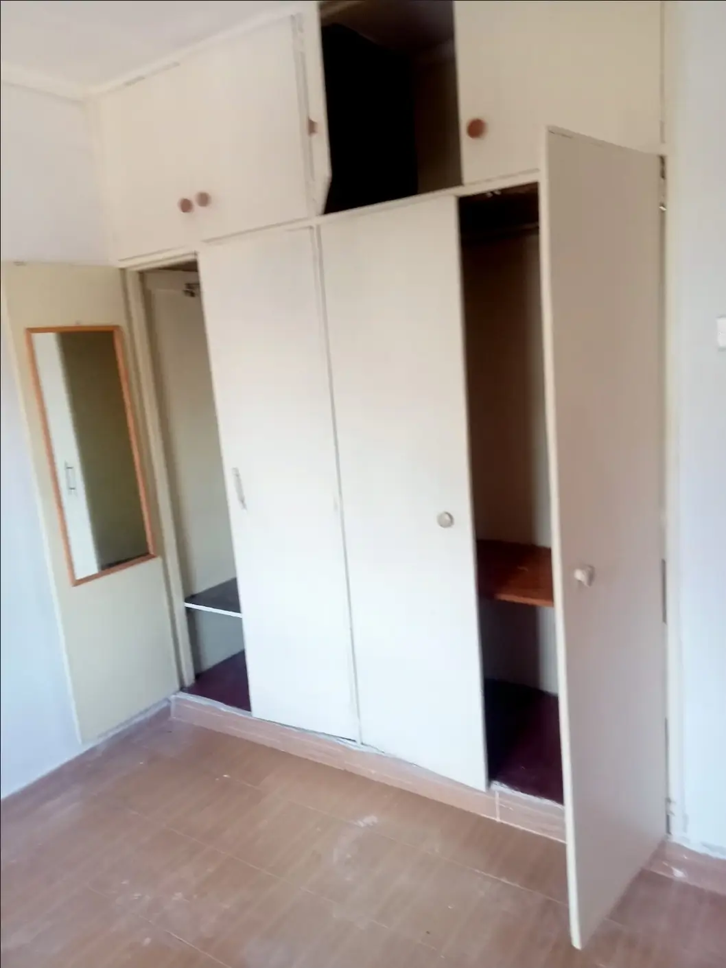 Bedroom with built-in white wardrobes and mirror