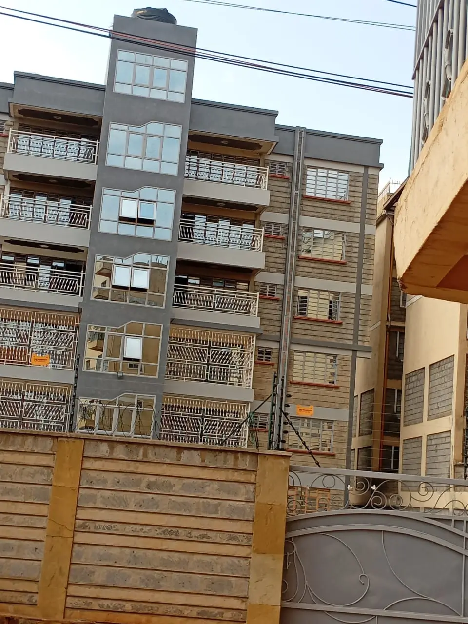 Multi-story apartment building facade with balconies and gate