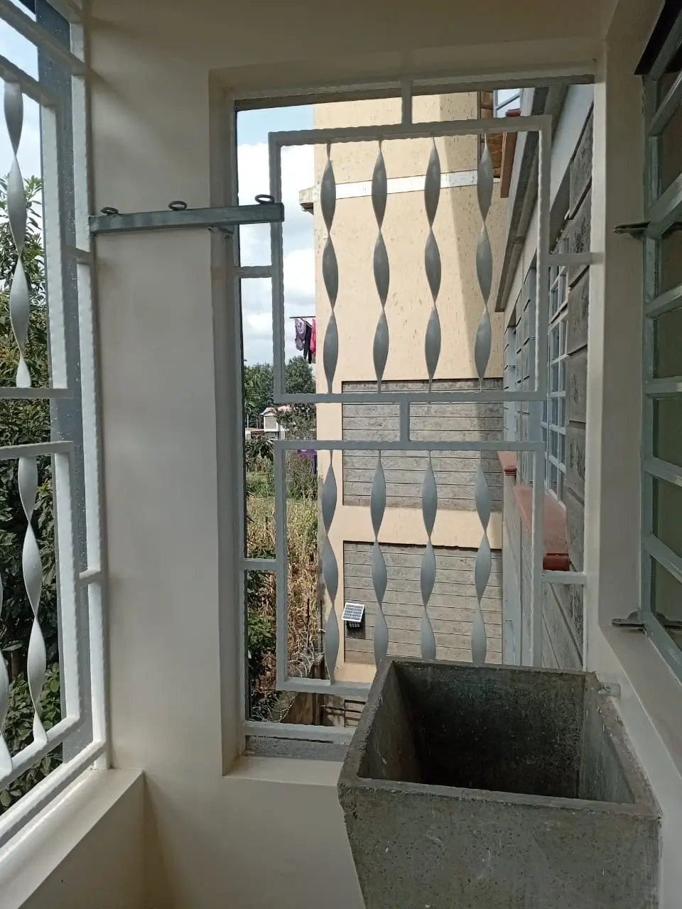 Balcony with open door overlooking residential building courtyard