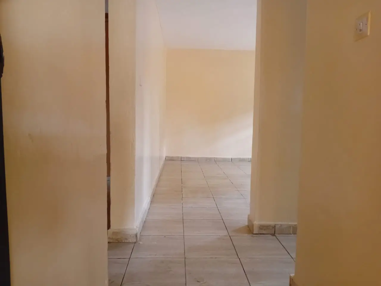 Bright corridor with tiled flooring and cream walls