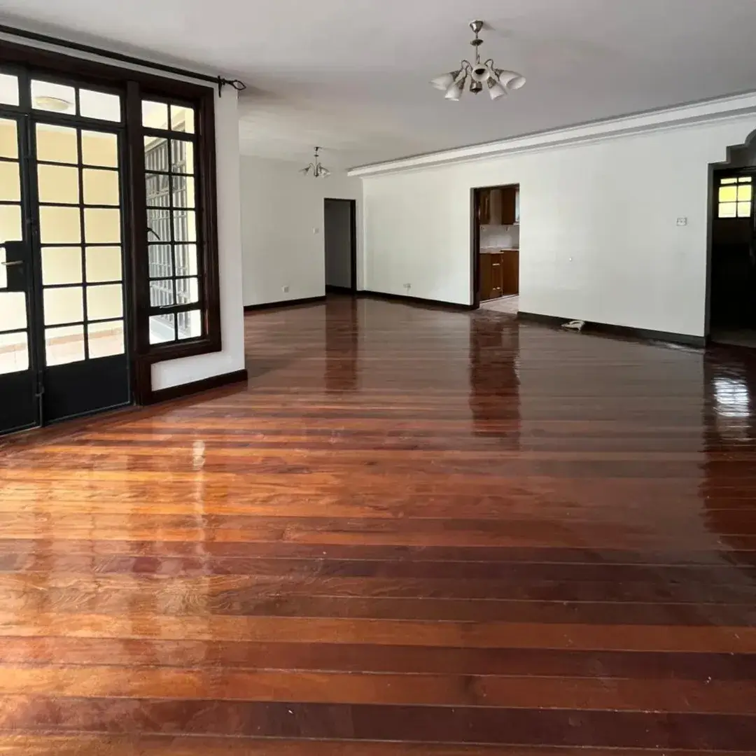 Spacious living room with polished wooden floors and glass doors