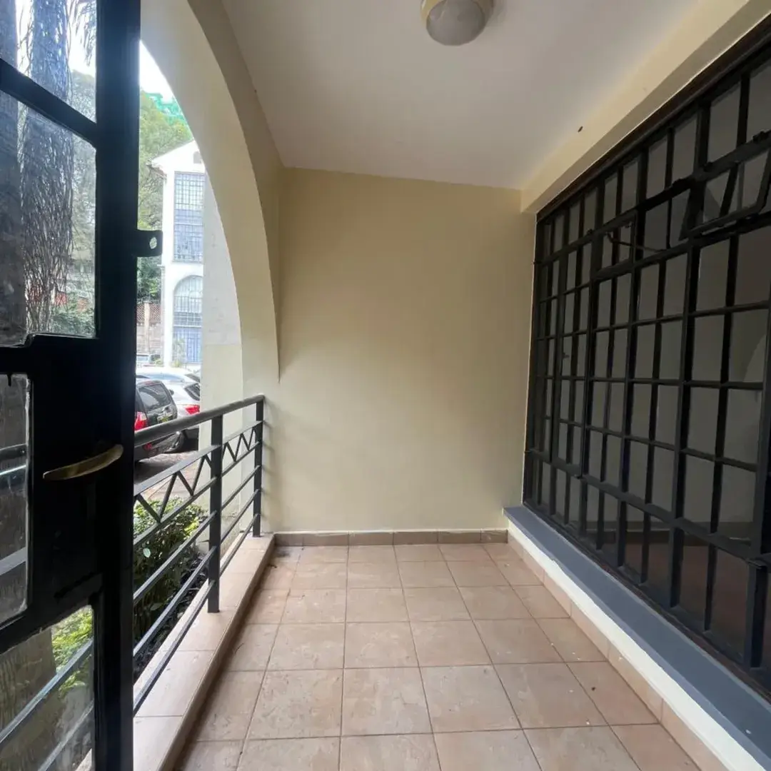 Covered balcony with tiled flooring and black metal railing