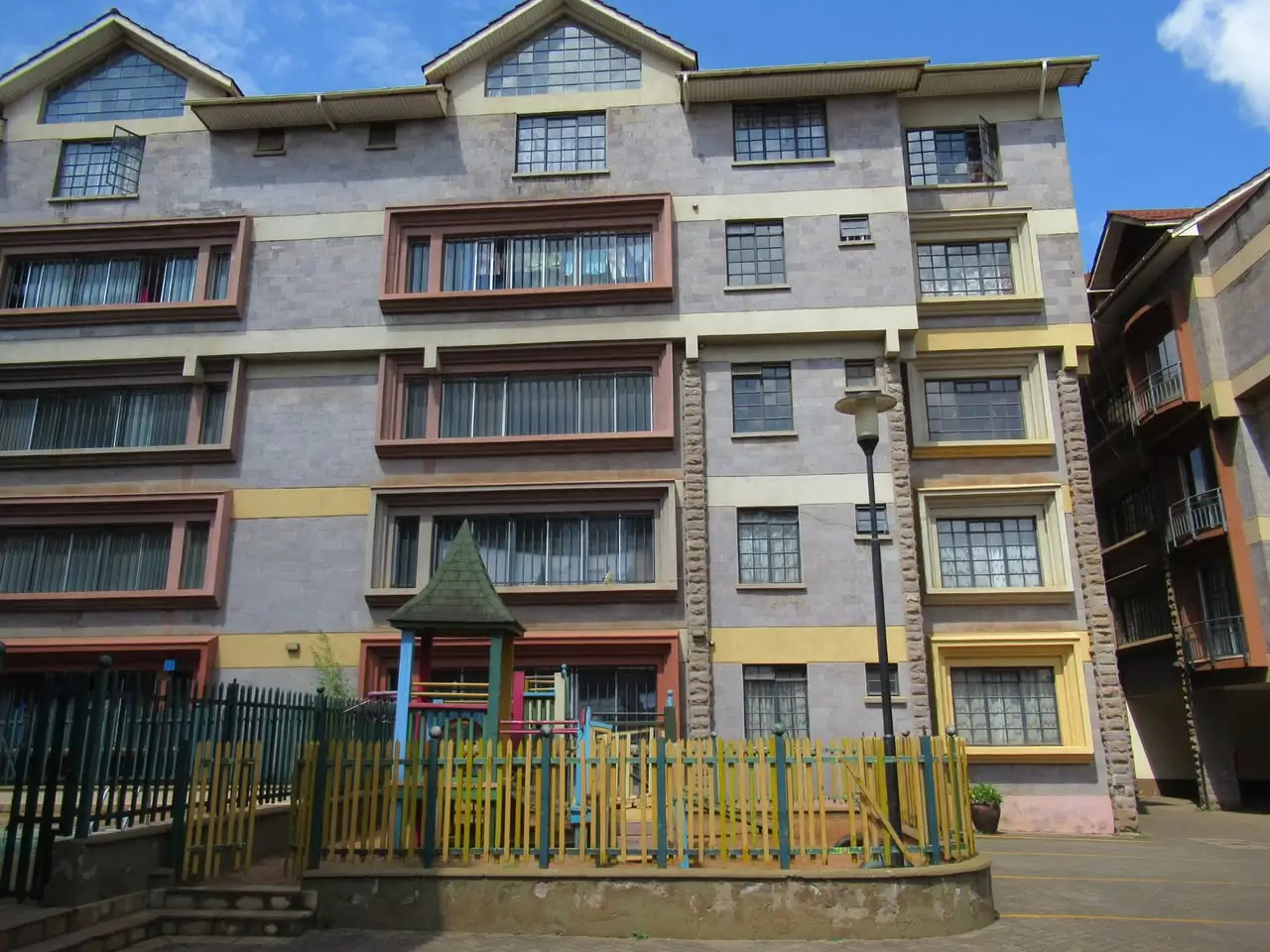 Multi-story residential building facade with balconies and entrance gate