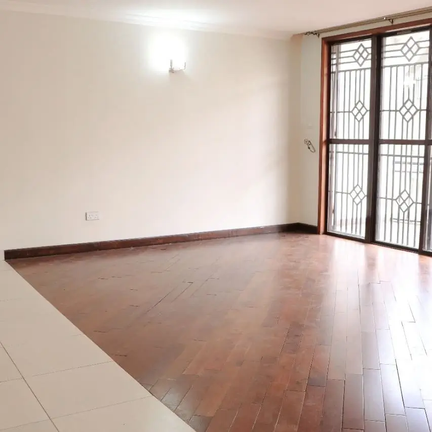 Spacious empty living room with wooden flooring and glass doors