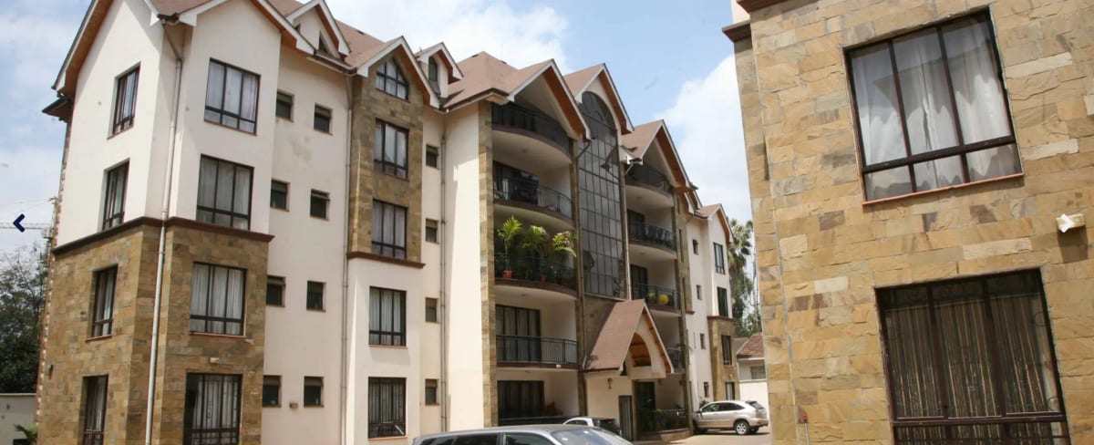 Multi-story residential building facade with mixed stone and white render