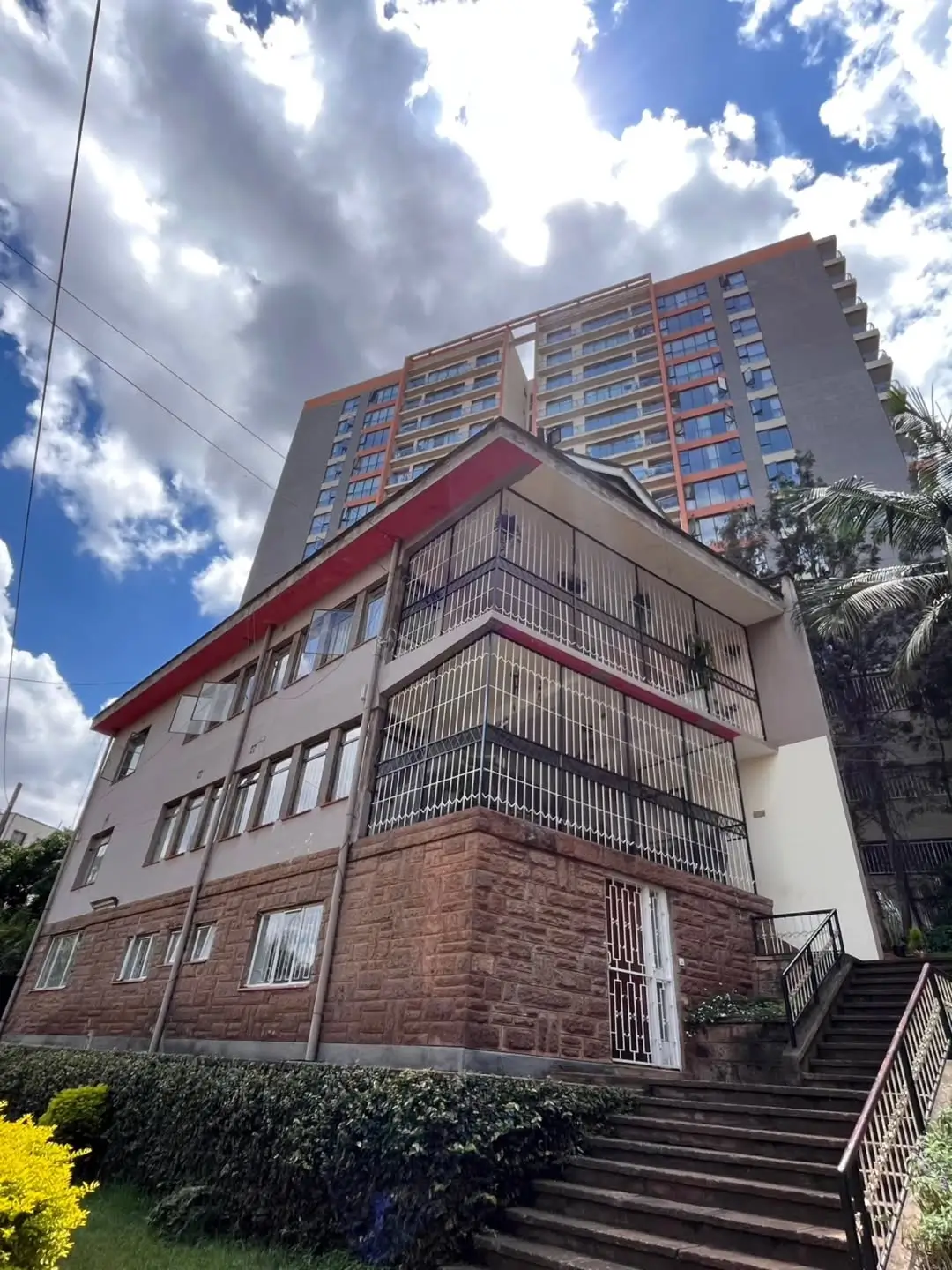 Multi-story residential building facade with red trim details