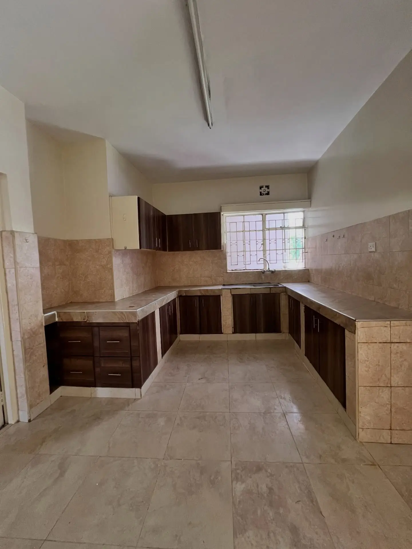 U-shaped kitchen with dark cabinetry and tiled walls