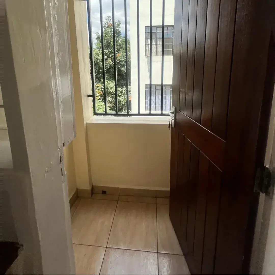 Small balcony with tiled floor and barred window opening