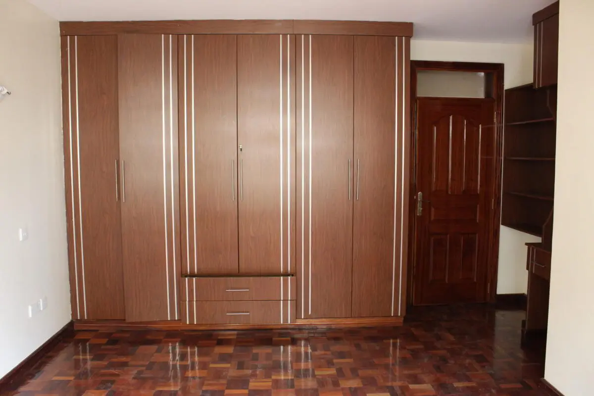Spacious bedroom with large wooden built-in wardrobe