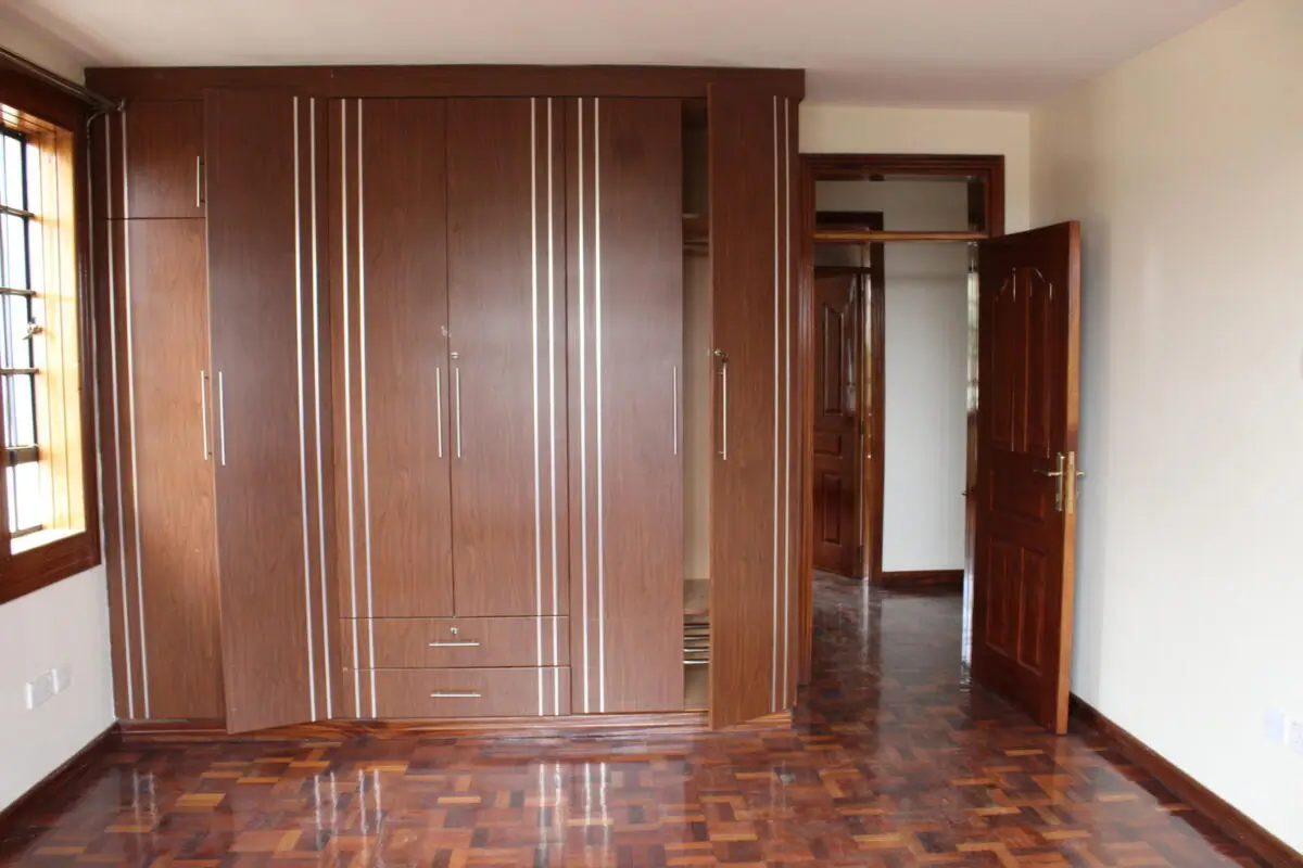 Master bedroom with built-in wooden wardrobe and parquet flooring
