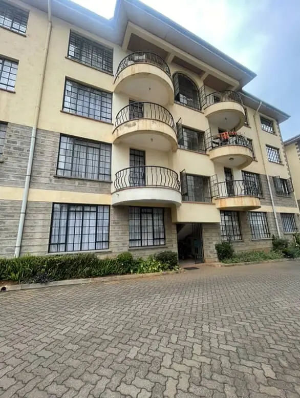 Modern residential apartment building with curved balconies and brick driveway