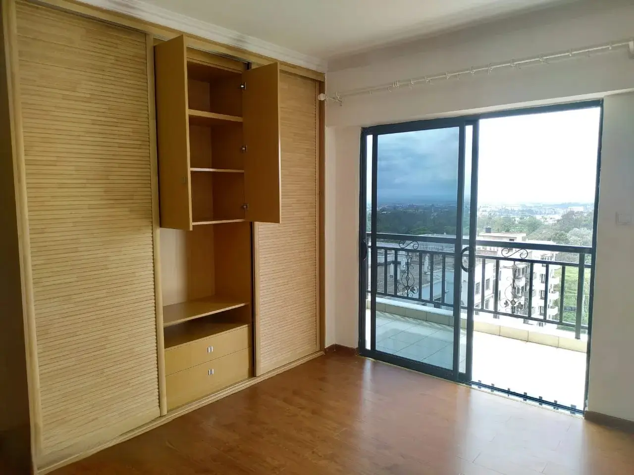 Spacious bedroom with built-in wardrobe and balcony views