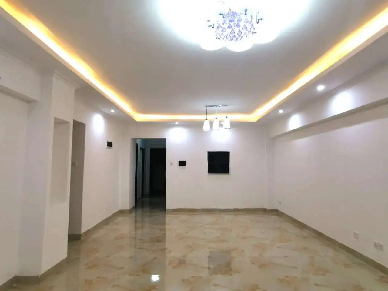 Modern living room with cove lighting and polished concrete flooring
