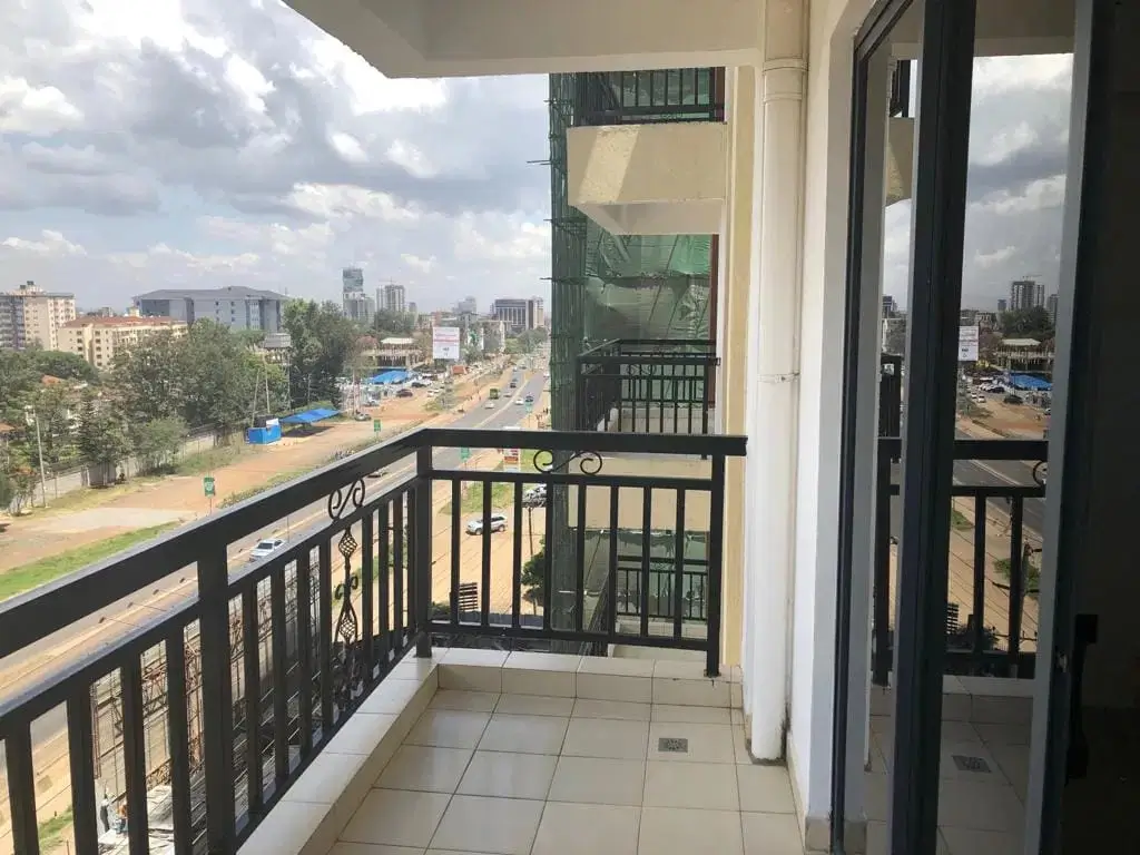 Spacious balcony with city skyline and green space views