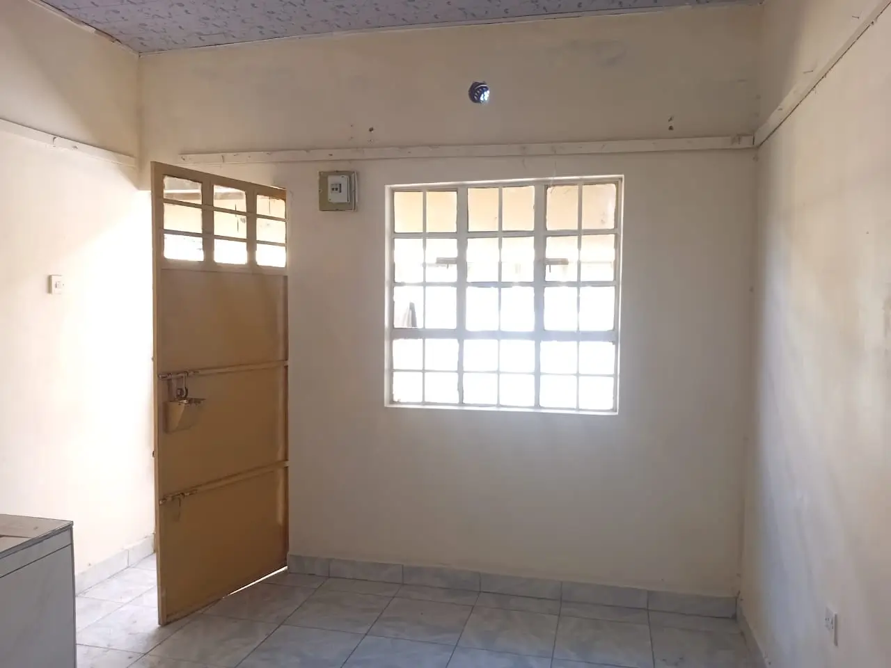 Bright living space with large window and wooden entrance door