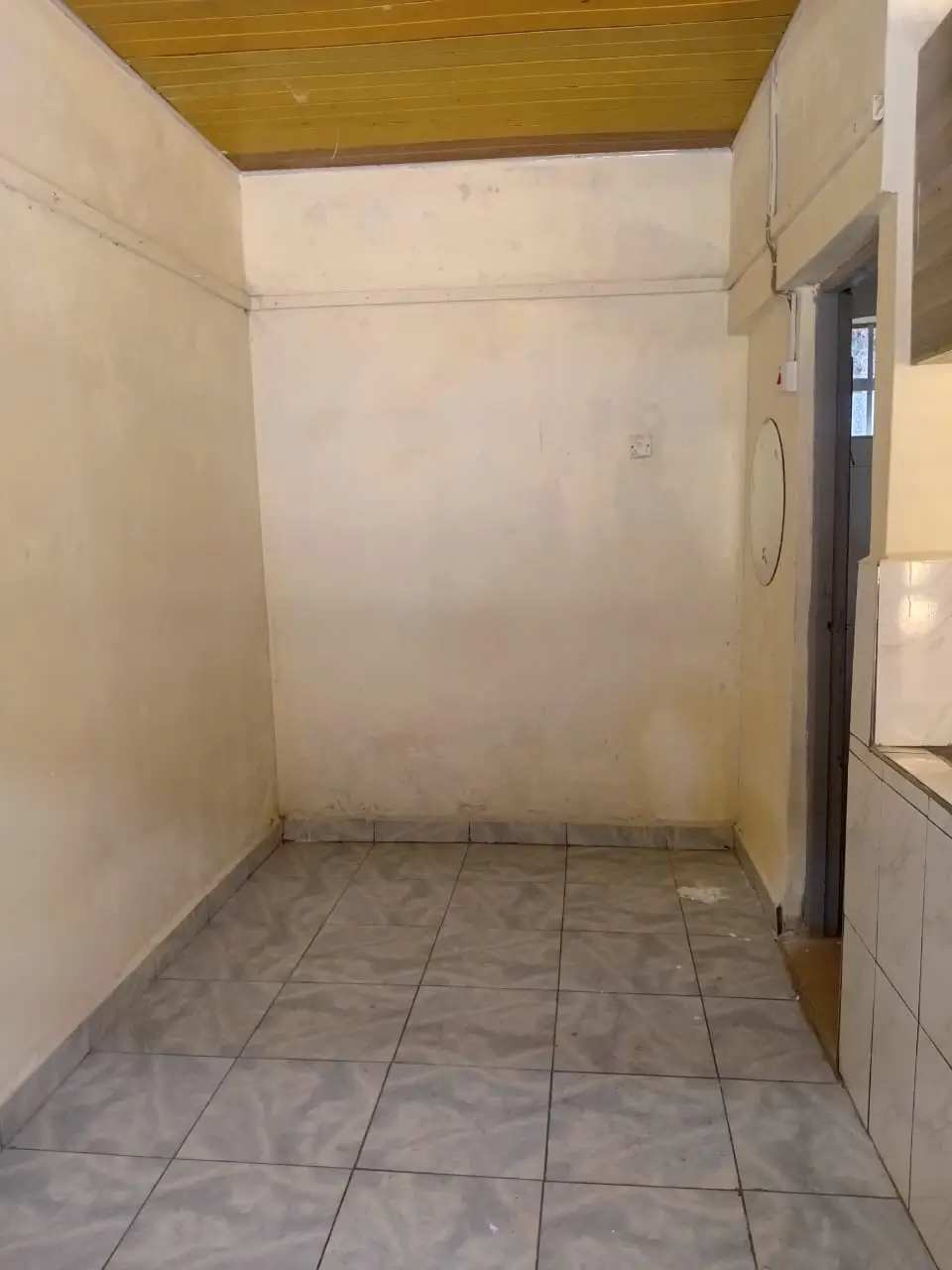 Compact kitchen with tiled flooring and wooden ceiling