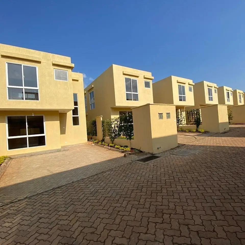 Yellow residential compound with paved driveway and multiple units