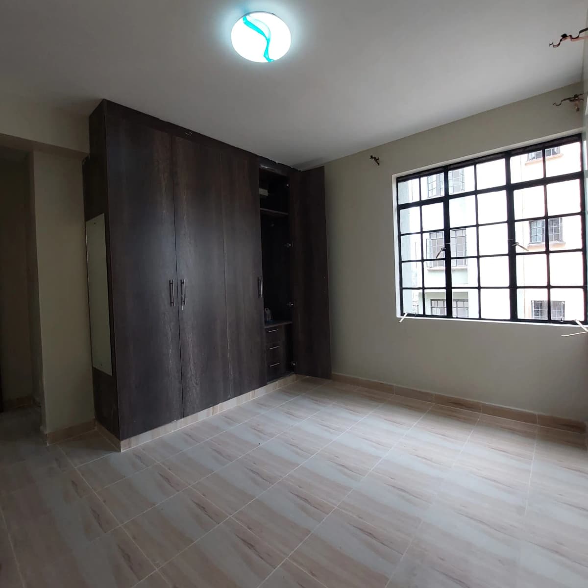 Spacious bedroom with built-in dark wardrobes and natural light