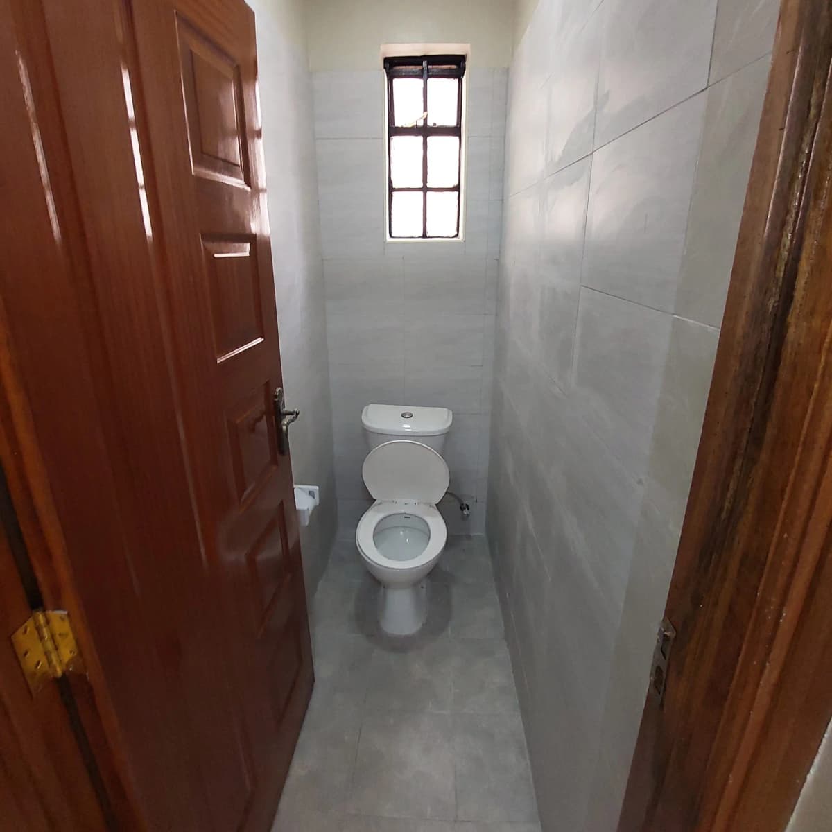 Compact toilet room with ceramic WC and small window