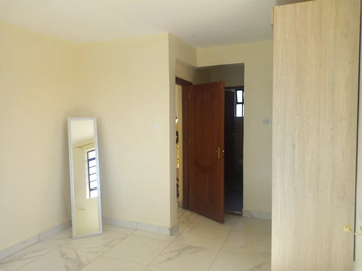 Empty corridor with brown door and light tile flooring