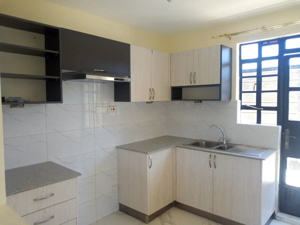 Modern kitchen with white cabinetry, stainless steel sink, blue door