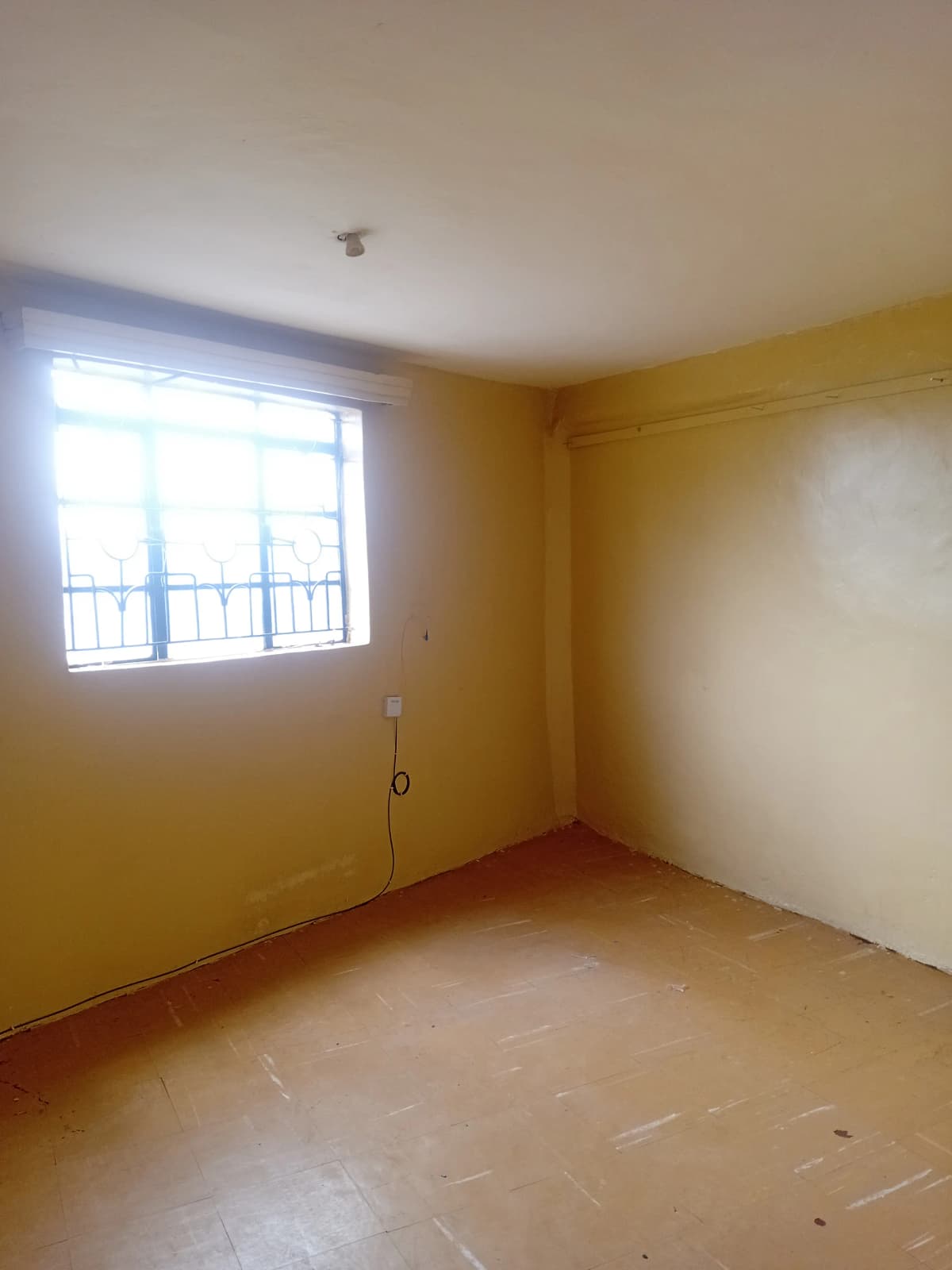 Empty bedroom with yellow walls and natural light